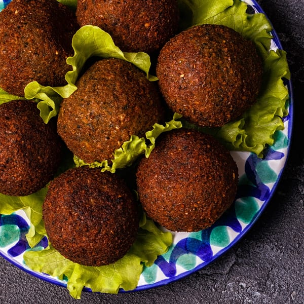 Crispy Mediterranean falafel balls on a bed of fresh lettuce, served on a decorative plate.
